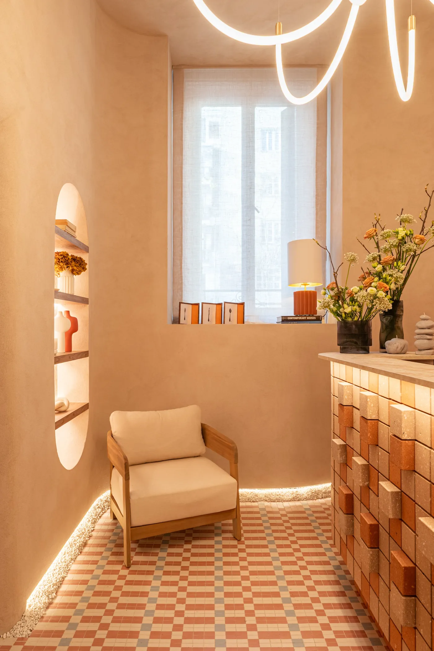An armchair in a peach room with lit Manhattan panels along the counter
