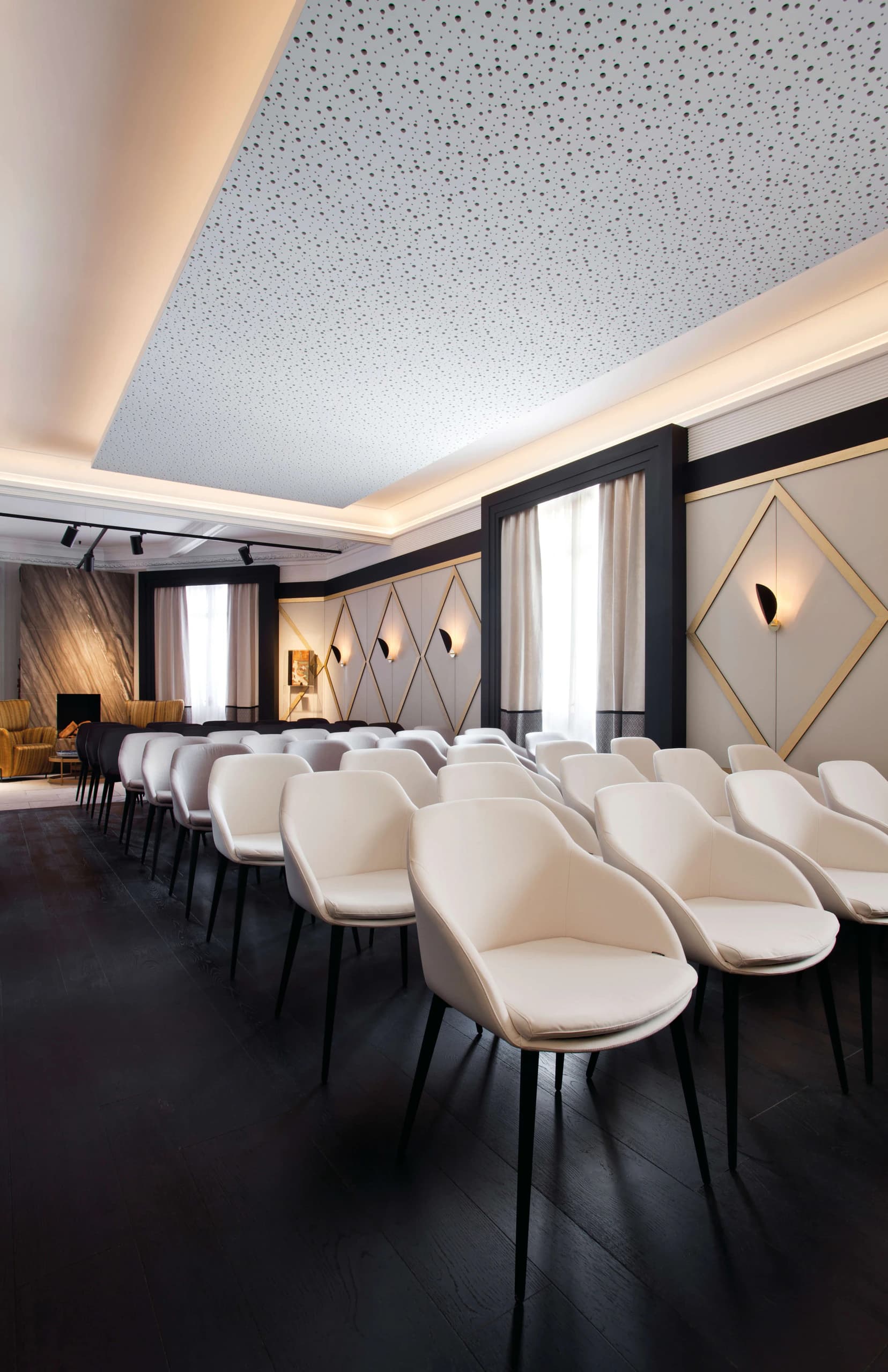 Rows of white upholstered chairs in the auditorium at Casa Decor 2019
