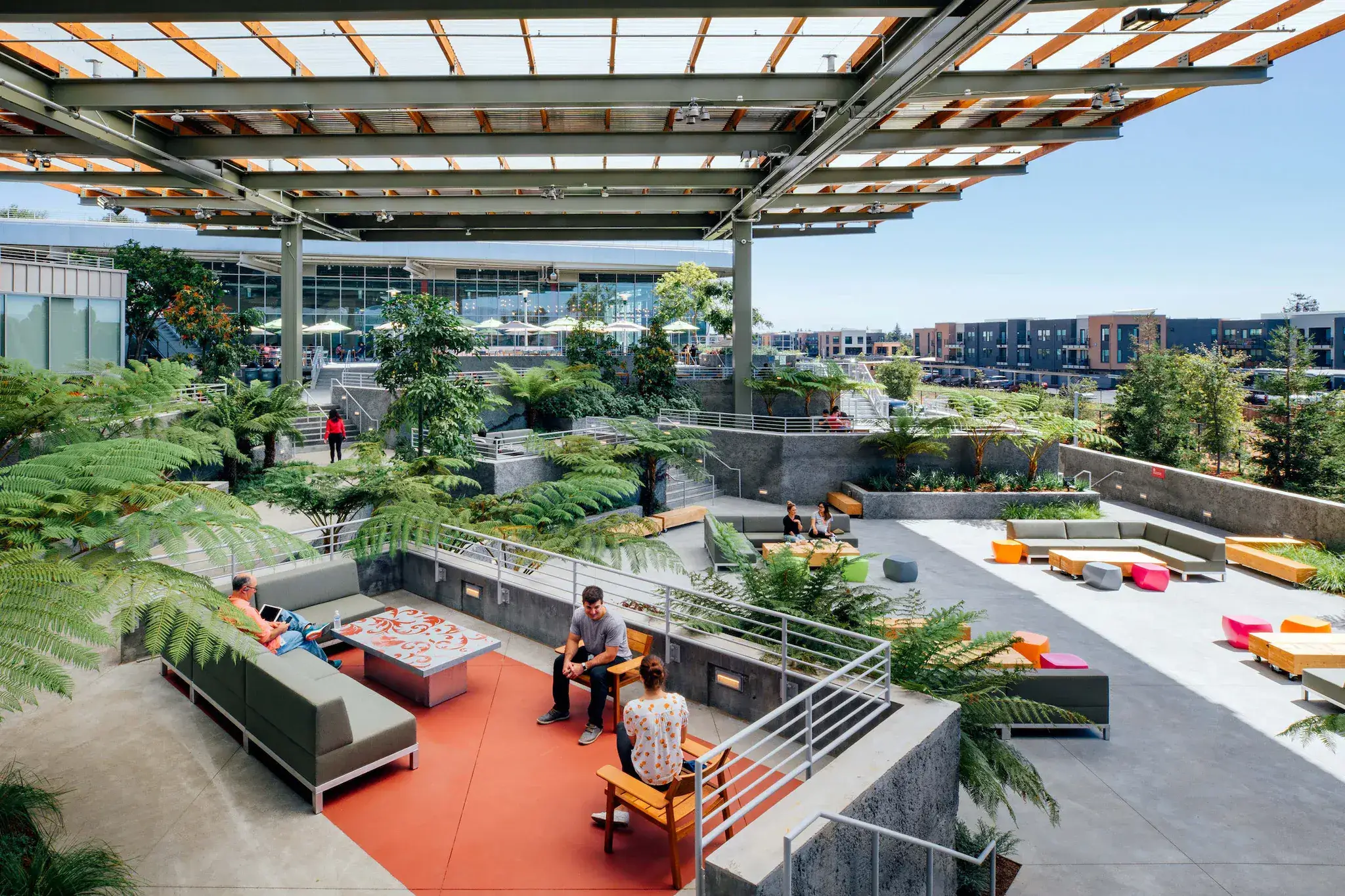 Lounge seating among ferns on a rooftop terrace with an orange deck at Meta headquarters