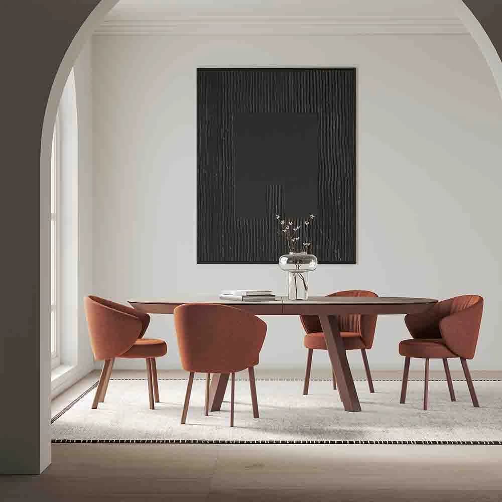 Esla dining table with rust upholstered chairs in an arched white interior