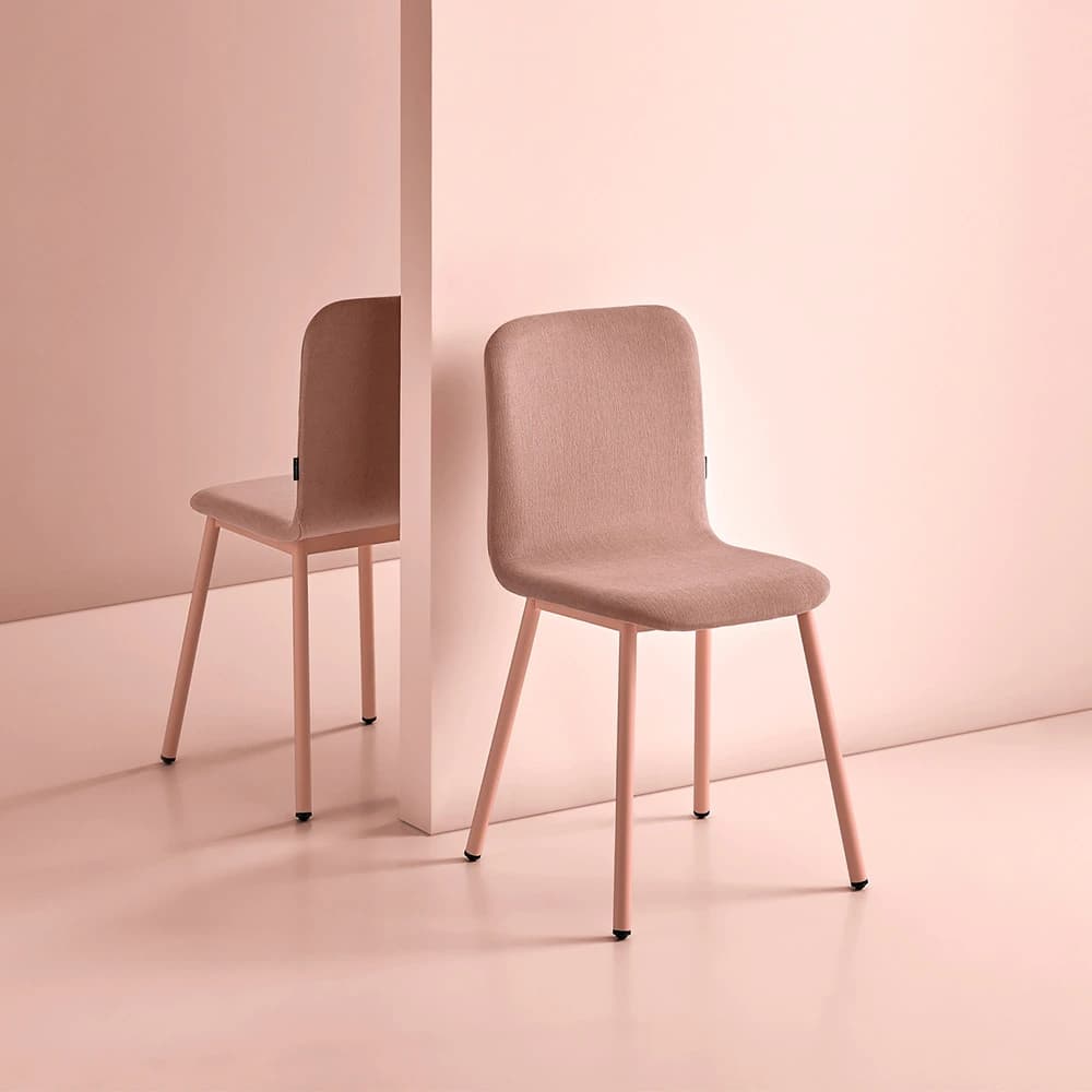 Two upholstered Pepper chairs in a pink interior