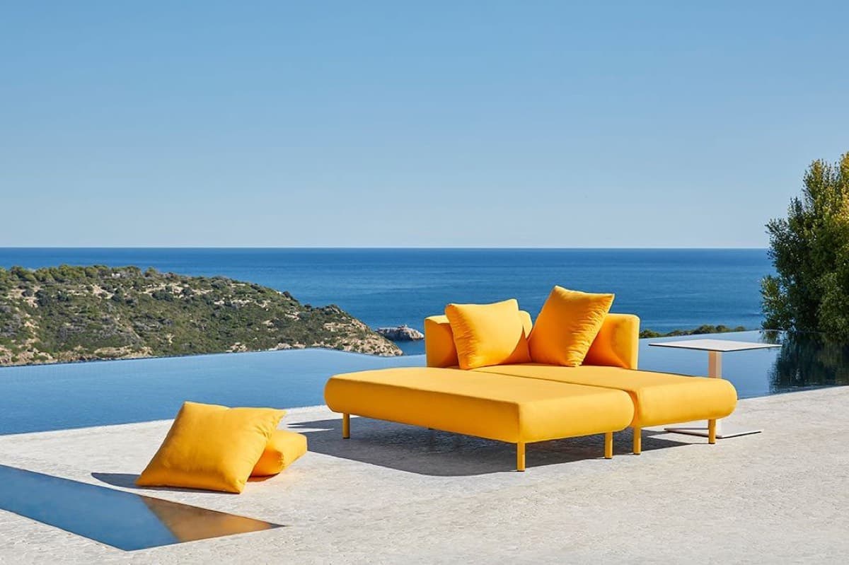 A yellow Salinas modular sofa beside an infinity pool above the sea