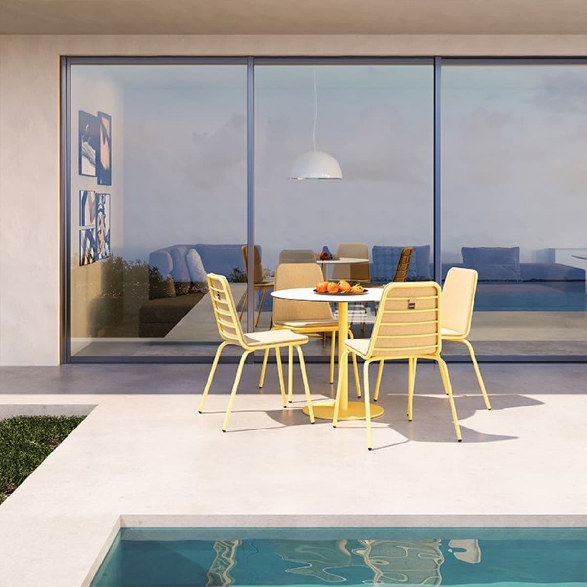 Yellow Sorell chairs around a round table beside a pool