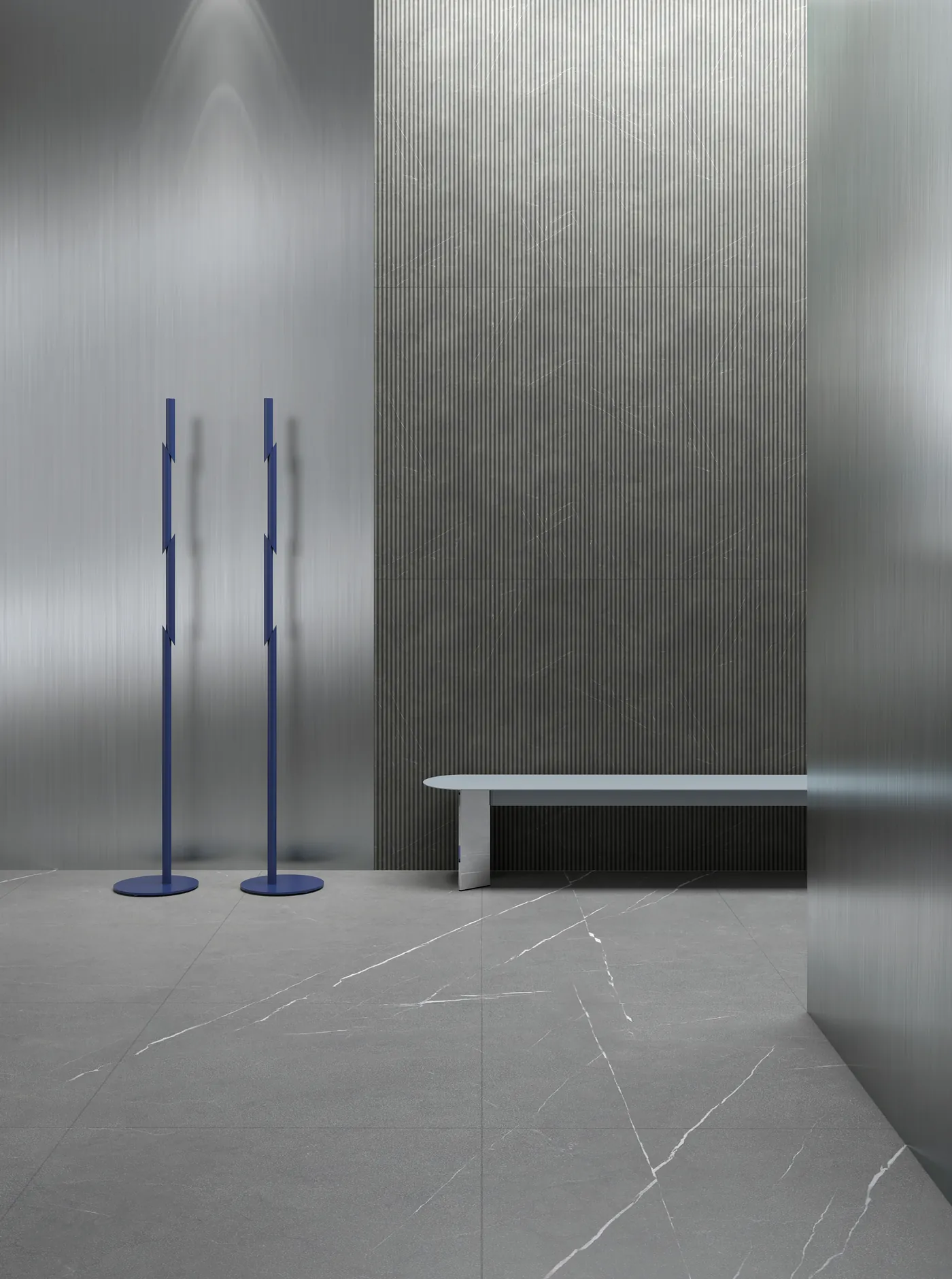 Two blue Naname coat stands beside a bench in a grey stone lobby